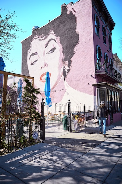 A three-story mural of actress Elizabeth Taylor overlooks the Dacha Beer Garden, which opened in D.C.’s Shaw neighborhood in 2013. The beer garden is just one of dozens of new eateries that have opened in Shaw — the convention center’s neighborhood — in recent years.